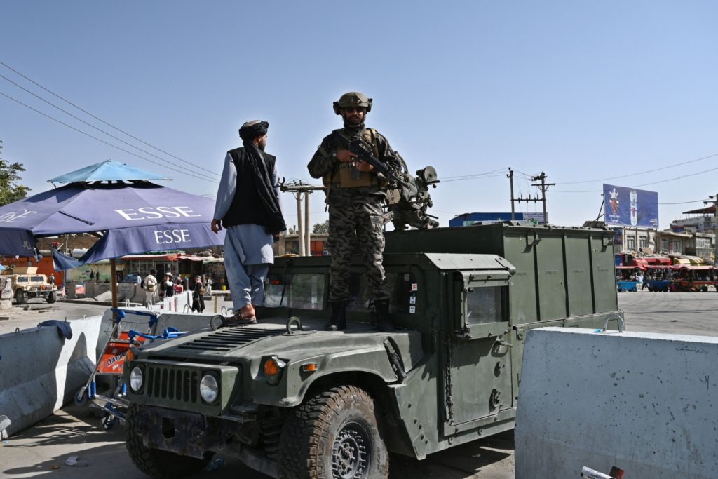 A Taliban Badri fighter, a "special forces" unit, stands guard on Humvee vehicle at the main entrance gate of Kabul airport in Kabul on August 28, 2021, following the Taliban stunning military takeover of Afghanistan. (Photo by WAKIL KOHSAR / AFP) (Photo by WAKIL KOHSAR/AFP via Getty Images)