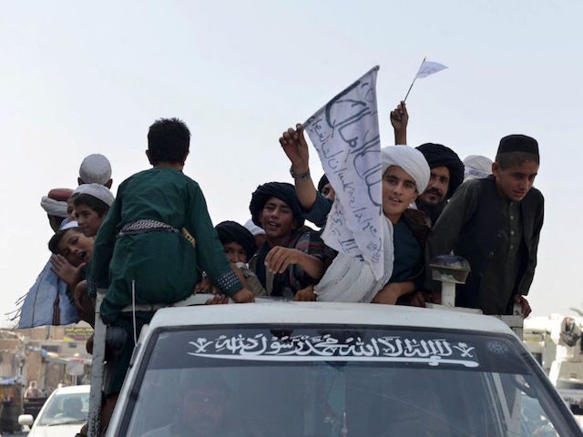 TOPSHOT - Youths supporting the Taliban wave Taliban flags atop a vehicle while marching with others along a street in Kandahar on August 31, 2021, as they celebrate after the US has pulled all its troops out of the country to end a brutal 20-year war -- one that started …
