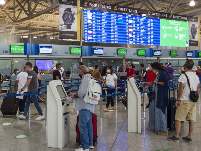 ATHENS, GREECE - JUNE 15: Passengers wear protective face masks and gloves as they check in for flights at Eleftherios Venizelos International Airport in Athens on June 15, 2020 in Athens, Greece. The country removed most restrictions on travel from EU countries today in an effort to jumpstart its tourist …
