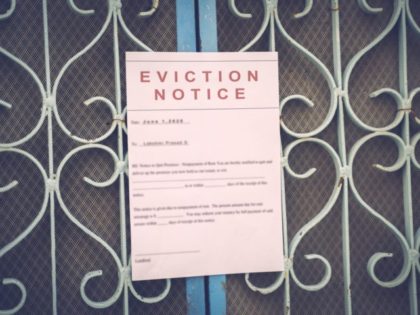 Foreclosed or eviciton notice on a main door with blurred details of a house with vintage filter