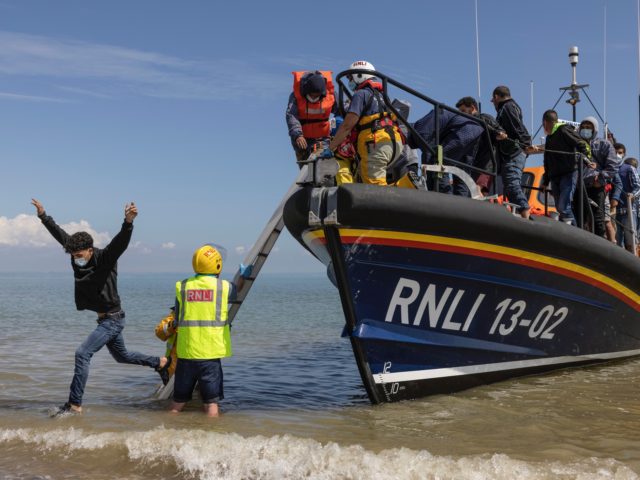 DUNGENESS, ENGLAND - AUGUST 04: A group of around 40 migrants arrive via the RNLI (Royal National Lifeboat Institution) on Dungeness beach on August 04, 2021 in Dungeness, England. UK Home Secretary Priti Patel recently said that the government would seek to criminalise irregular migration, accusing people smugglers of "exploiting …