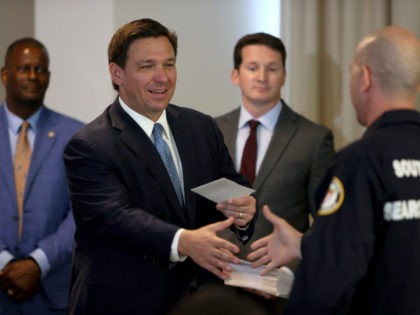 SURFSIDE, FLORIDA - AUGUST 10: Florida Gov. Ron DeSantis presents a check to a first responder during an event to give out bonuses to them held at the Grand Beach Hotel Surfside on August 10, 2021 in Surfside, Florida. DeSantis gave out some of the $1,000 checks that the Florida …