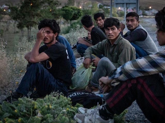 VAN, TURKEY - JULY 06: Afghan migrants look on as a Jandarma officer arrests the driver of