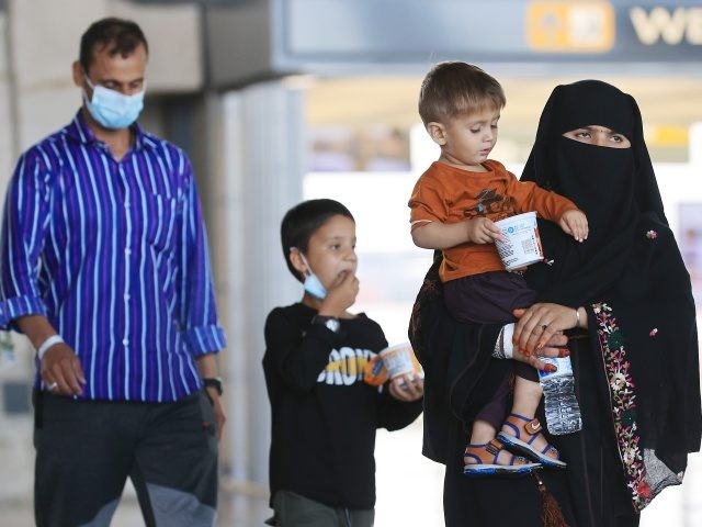 DULLES, VIRGINIA - AUGUST 27: Refugees arrive at Dulles International Airport after being evacuated from Kabul following the Taliban takeover of Afghanistan August 27, 2021 in Dulles, Virginia. Refugees continued to arrive in the United States one day after twin suicide bombings at the gates of the airport in Kabul …