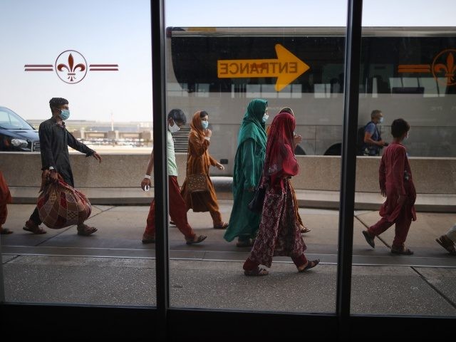 DULLES, VIRGINIA - AUGUST 27: Refugees board buses that will take them to a processing center after they arrive at Dulles International Airport after being evacuated from Kabul following the Taliban takeover of Afghanistan August 27, 2021 in Dulles, Virginia. Refugees continued to arrive in the United States one day …
