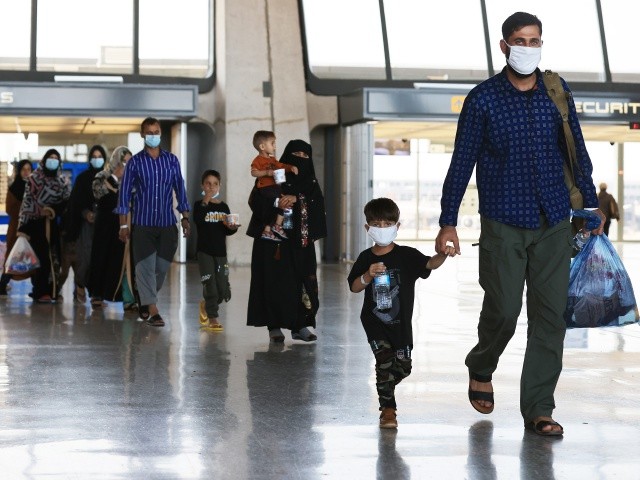 DULLES, VIRGINIA - AUGUST 27: Refugees arrive at Dulles International Airport after being evacuated from Kabul following the Taliban takeover of Afghanistan August 27, 2021 in Dulles, Virginia. Refugees continued to arrive in the United States one day after twin suicide bombings at the gates of the airport in Kabul killed 13 U.S. military service members and nearly 100 Afghans. “We will not forgive,” President Joe Biden warned ISIS, who claimed responsibility for the attacks. “We will not forget. We will hunt you down and make you pay.” (Photo by Chip Somodevilla/Getty Images)