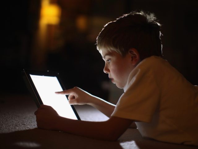 KNUTSFORD, UNITED KINGDOM - NOVEMBER 29: In this photograph illustration a ten-year-old boy uses an Apple Ipad tablet computer on November 29, 2011 in Knutsford, United Kingdom. Tablet computers have become the most wanted Christmas present for children between the ages of 6-11 years. Many parents are having to share …