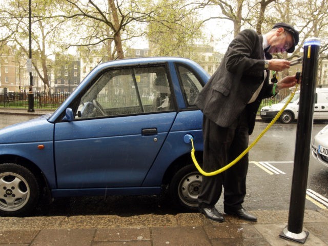 LONDON, ENGLAND - APRIL 16: Alexander Skeaping, an owner of a G-Wiz electric vehicle plug