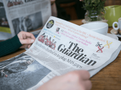 BRISTOL, ENGLAND - JANUARY 15: In this photo illustration a woman reads the new tabloid size The Guardian newspaper that was launched today with a new masthead on January 15, 2018 in Bristol, England. In a cost-cutting move, publisher Guardian News & Media has ditched the distinctive Berliner size after …