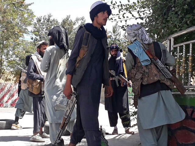 Taliban fighters stand along the roadside in Ghazni on August 12, 2021, as Taliban move closer to Afghan capital after taking Ghazni city. (Photo by - / AFP) (Photo by -/AFP via Getty Images)