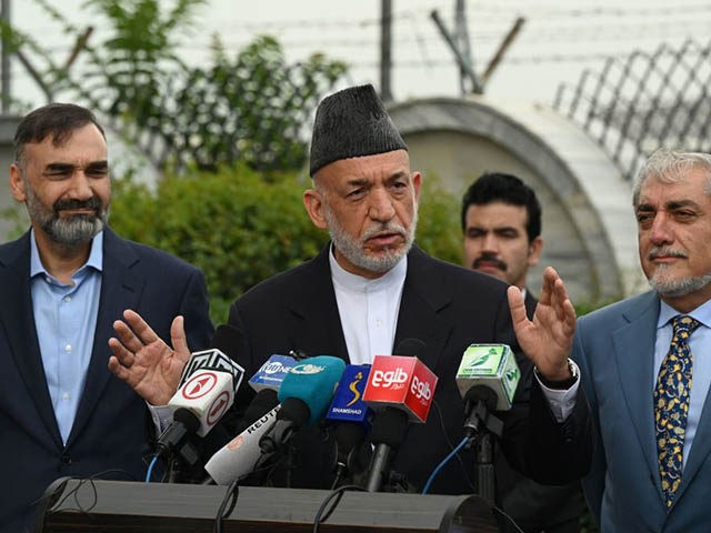 Former Afghan President Hamid Karzai (C) speaks next to Chairman of the High Council for N