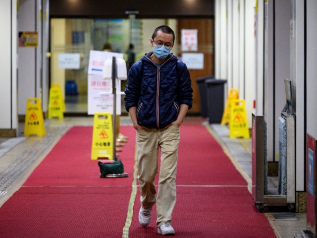 This picture taken on February 13, 2020 shows doctor Alfred Wong walking out from a Hong Kong hospital following an interview with AFP in Hong Kong. - The 38-year-old volunteered to join staff on isolation wards -- dubbed "the dirty team" -- to avoid the risk of being called up …