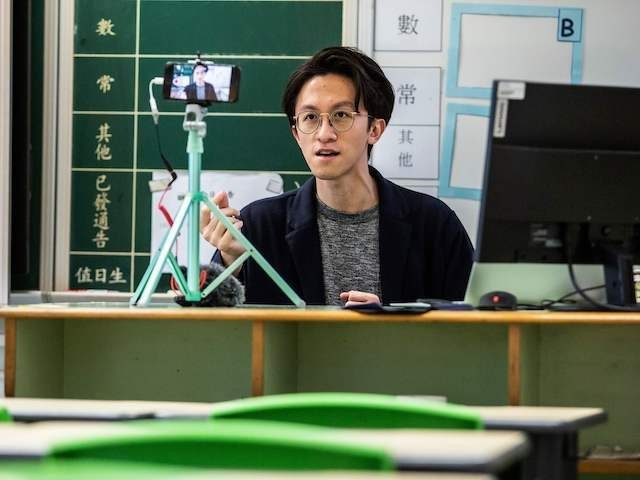 TOPSHOT - In this photo taken on March 6, 2020, primary school teacher Billy Yeung records a video lesson for his students who have had their classes suspended due to the COVID-19 coronavirus, in his empty classroom in Hong Kong. - In Hong Kong, schools have been shut since early …