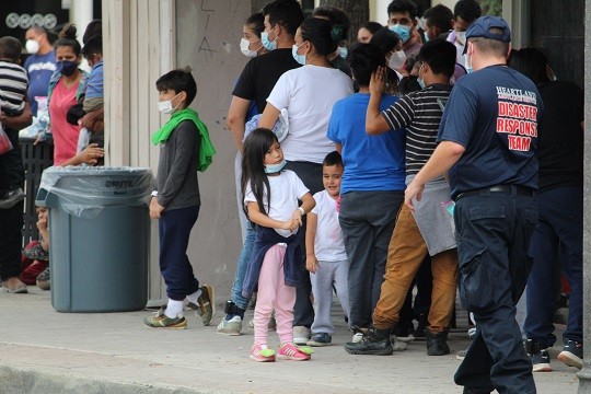 Migrants families, including small children, wait for entry to a Catholic Charities shelter after being released by Border Patrol (Photo: Randy Clark/Breitbart Texas)