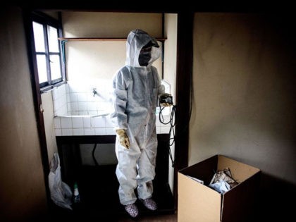 TOPSHOT - In this picture taken on August 19, 2017, a worker for special cleaning, wearing a protective suit, takes pictures of a man's apartment who died alone and left decomposing for three weeks, in Tokyo. There are no official data for the number of people dying alone who stay …