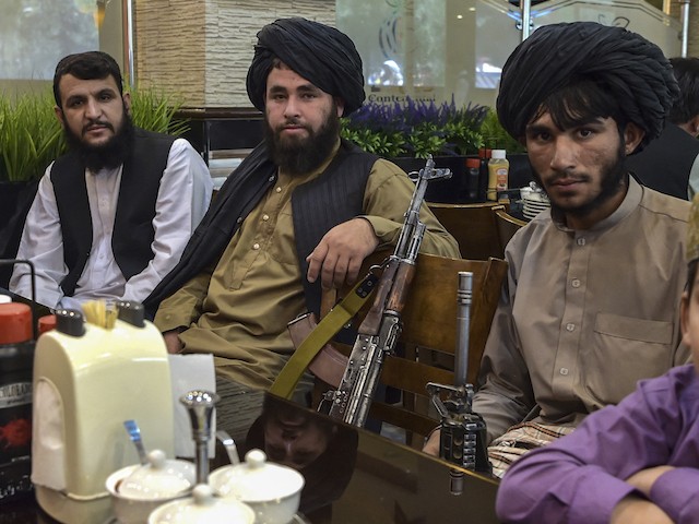 TOPSHOT - Taliban fighters wait for their meals to be served as they lunch at a restaurant in Kabul on August 26, 2021 after Taliban's military takeover following the US troop withdrawal. (Photo by WAKIL KOHSAR / AFP) (Photo by WAKIL KOHSAR/AFP via Getty Images)