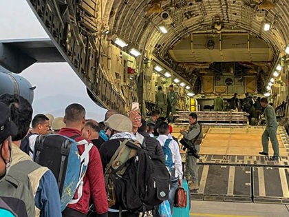 Indian Nationals queue to board an Indian military aircraft at the airport in Kabul on Aug