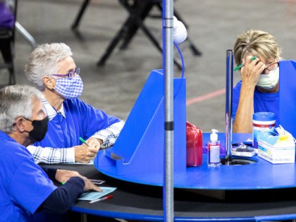 PHOENIX, AZ - MAY 01: Contractors working for Cyber Ninjas, who was hired by the Arizona State Senate, examine and recount ballots from the 2020 general election at Veterans Memorial Coliseum on May 1, 2021 in Phoenix, Arizona. The Maricopa County ballot recount comes after two election audits found no …