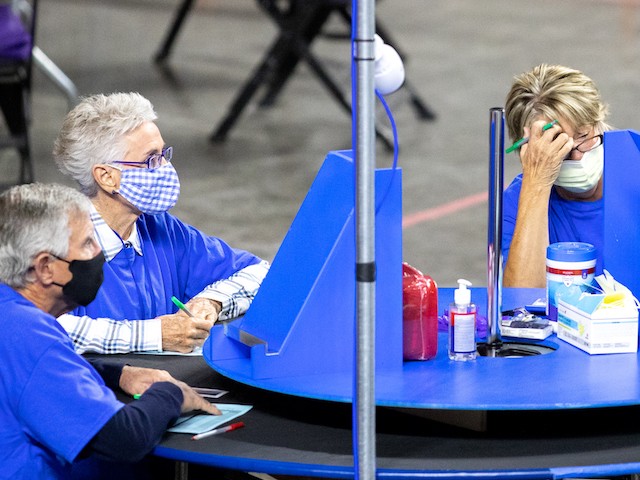 PHOENIX, AZ - MAY 01: Contractors working for Cyber Ninjas, who was hired by the Arizona State Senate, examine and recount ballots from the 2020 general election at Veterans Memorial Coliseum on May 1, 2021 in Phoenix, Arizona. The Maricopa County ballot recount comes after two election audits found no evidence of widespread fraud. (Photo by Courtney Pedroza/Getty Images)