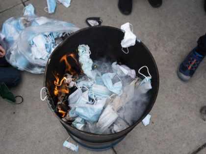 BOISE, ID - MARCH 06: Attendees toss surgical masks into a fire during a mask burning event at the Idaho Statehouse on March 6, 2021 in Boise, Idaho. Citizens and politicians, including the Lieutenant Governor Janice McGeachin, gathered in at least 20 cities across the state to protest COVID-19 restrictions. …