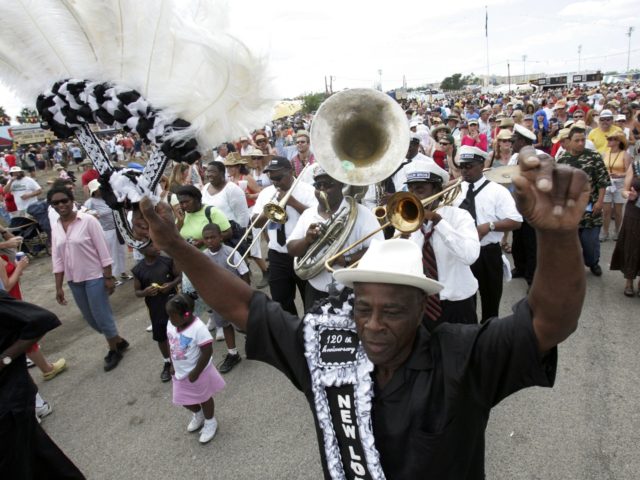 NEW ORLEANS - APRIL 30: Members of the Young Olympia Aid and New Look Social Aid & Pleasure Clubs, with Paulin Brothers Brass Band, parade through out the crowd during the New Orleans Jazz & Heritage Festival April 30, 2006 in New Orleans, Louisiana. Hurricane Katrina hit the area last …