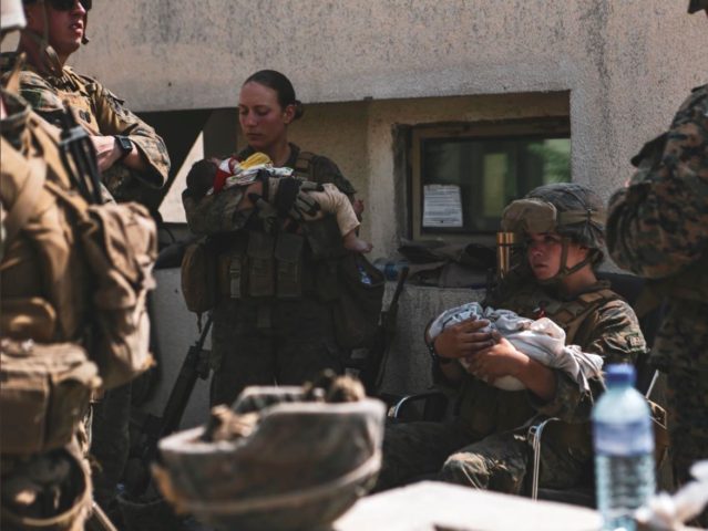 U.S. Marine Sgt. Nicole Gee (center left) seen caring for a baby days before she was killed by a terrorist attack in Kabul, Afghanistan. @DeptofDefense / Twitter.