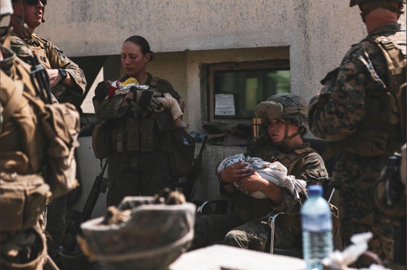 U.S. Marine Sgt. Nicole Gee seen caring for a baby days before she was killed by a terrorist attack in Kabul, Afghanistan. @DeptofDefense / Twitter.