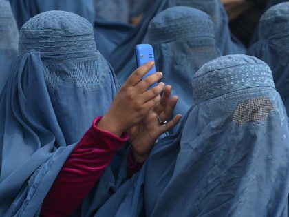An Afghan woman takes a photograph with her mobile phone as she and supporters attend the