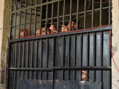 In this picture taken on August 3, 2020, inmates watch from behind a closed gate after a r