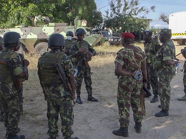 In this image made from video, Rwandan and Mozambican soldiers gather at the airport in Mocimboa da Praia, Cabo Delgado province, Mozambique Monday, Aug. 9, 2021. Fresh from recapturing the strategic northern Mozambican port of Mocimboa da Praia held by Islamic extremist rebels for a year, Rwandan and Mozambican troops say they are pursuing the insurgents into the surrounding areas. (AP Photo/Marc Hoogsteyns)