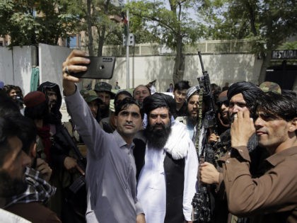 Afghans take selfie wit Taliban fighters during patrol in the city of Kabul, Afghanistan, Thursday, Aug. 19, 2021. The Taliban celebrated Afghanistan's Independence Day on Thursday by declaring they beat the United States, but challenges to their rule ranging from running a country severely short on cash and bureaucrats to …
