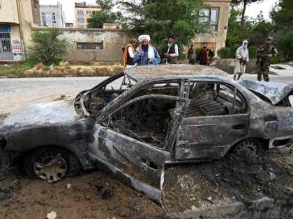 Taliban fighters investigate a damaged car after multiple rockets were fired in Kabul on August 30, 2021. - Rockets flew across the Afghan capital on August 30 as the US raced to complete its withdrawal from Afghanistan, with the evacuation of civilians all but over and terror attack fears high. …
