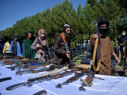 Taliban fighters put down their weapons as they surrendered to join the Afghanistan government during a ceremony in Herat on 24, 2021. (Photo by HOSHANG HASHIMI / AFP) (Photo by HOSHANG HASHIMI/AFP via Getty Images)