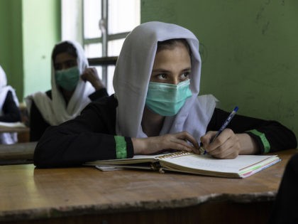 KABUL, AFGHANISTAN - JULY 24: Behishta ,13, takes notes during her 7th grade class at the Zarghoona high school on July 24 2021 in Kabul, Afghanistan. The Zarghoona girls high school is one of the largest in Kabul with 8,500 female students attending classes.Today was a brief school opening after …