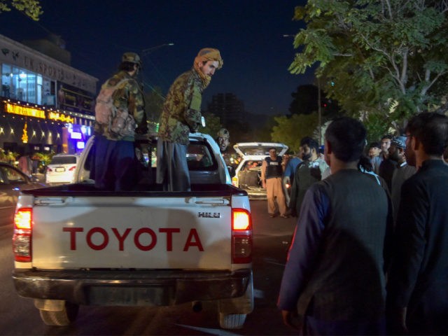 EDITORS NOTE: Graphic content / Taliban fighters stand on a pickup truck outside a hospital as volunteers bring injured people for treatment after two powerful explosions, which killed at least six people, outside the airport in Kabul on August 26, 2021. (Photo by WAKIL KOHSAR / AFP) (Photo by WAKIL …