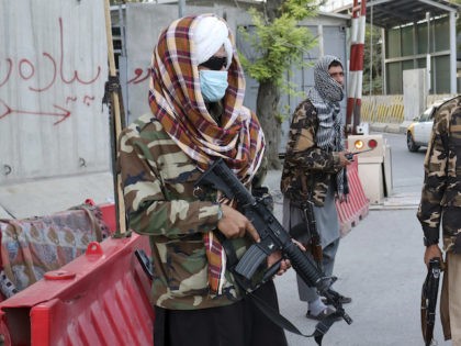 Taliban fighters stand guard at a checkpoint on the road in Kabul, Afghanistan, Wednesday,