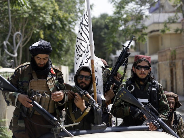 Taliban fighters display their flag on patrol in Kabul, Afghanistan, Thursday, Aug. 19, 20