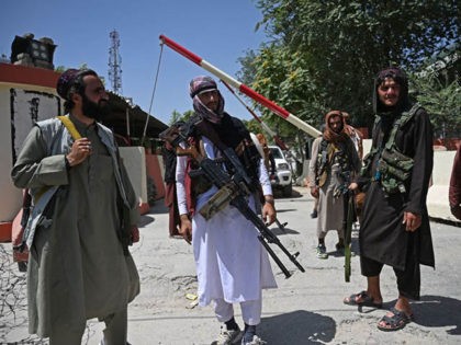 TOPSHOT - Taliban fighters stand guard along a roadside near the Zanbaq Square in Kabul on