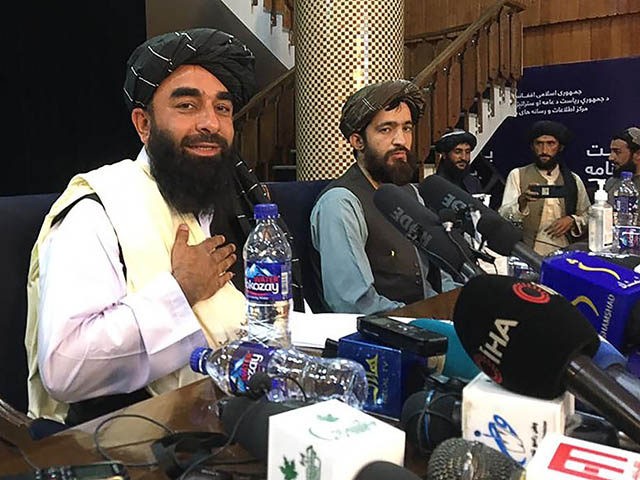 TOPSHOT - Taliban spokesperson Zabihullah Mujahid (L) gestures as he arrives to hold the first press conference in Kabul on August 17, 2021 following the Taliban stunning takeover of Afghanistan. (Photo by Hoshang HASHIMI / AFP) (Photo by HOSHANG HASHIMI/AFP via Getty Images)