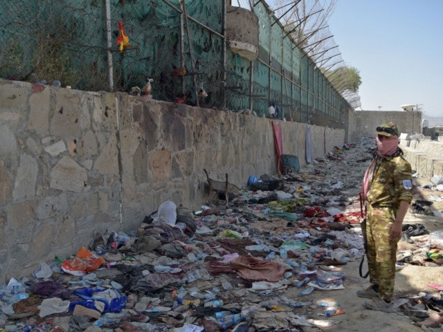 A Taliban fighter stands guard at the site of the August 26 twin suicide bombs, which killed scores of people including 13 US troops, at Kabul airport on August 27, 2021. (Photo by WAKIL KOHSAR / AFP) (Photo by WAKIL KOHSAR/AFP via Getty Images)