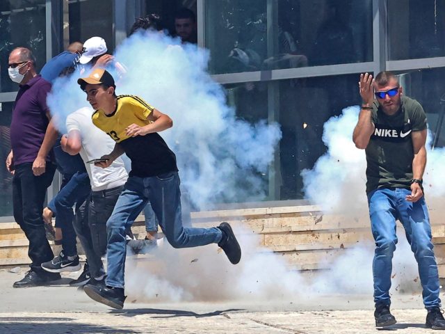 Palestinian protesters speed away to avoid tear gas amid clashes with Israeli security forces, at a demonstration following the Friday prayers at the Ibrahimi mosque (Tomb of the Patriarchs) denouncing Israeli construction plans at the site, in the divided city of Hebron in the occupied West Bank on August 13, …