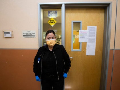 A security guard at the Mecca Health Clinic in Mecca, California wears a mask to protect h