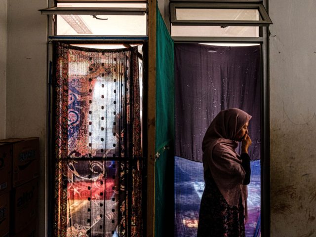 JAKARTA, INDONESIA - AUGUST 27: Sharifa, an Afghan refugee, pauses before entering a room