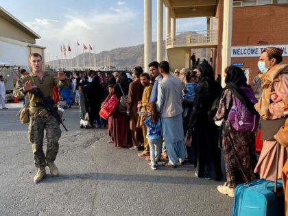 Afghan people queue up to board a U S military aircraft to leave Afghanistan, at the milit