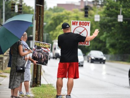 Protesters gather outside the Hamilton County Public Health building in Cincinnati's Corryville neighborhood, displaying anti-vaccine mandate signs to passing cars on William Howard Taft Road on Monday, Aug. 9, 2021.