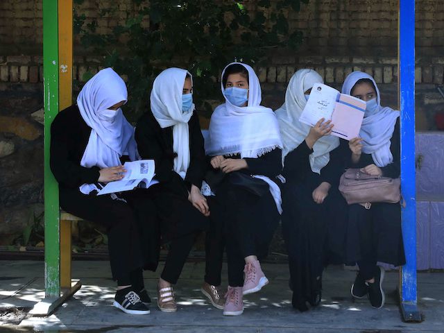 Schoolgirls sit at the schoolyard in Herat on August 17, 2021, following the Taliban stunning takeover of the country. (Photo by AREF KARIMI / AFP) (Photo by AREF KARIMI/AFP via Getty Images)