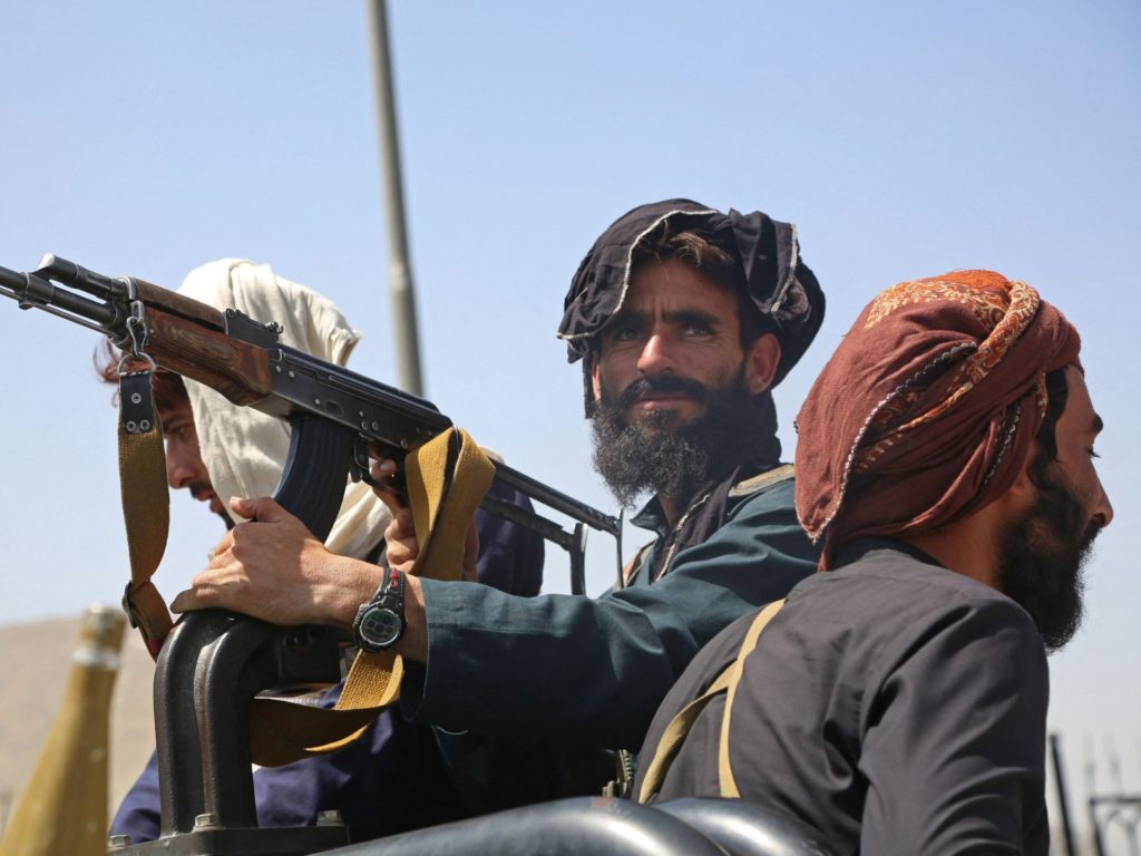 TOPSHOT - Taliban fighters stand guard in a vehicle along the roadside in Kabul on August 16, 2021, after a stunningly swift end to Afghanistan's 20-year war, as thousands of people mobbed the city's airport trying to flee the group's feared hardline brand of Islamist rule. (Photo by - / AFP) / The erroneous mention[s] appearing in the metadata of this photo by Zakeria HASHIMI has been modified in AFP systems in the following manner: [-] instead of [Zakeria Hashimi]. Please immediately remove the erroneous mention[s] from all your online services and delete it (them) from your servers. If you have been authorized by AFP to distribute it (them) to third parties, please ensure that the same actions are carried out by them. Failure to promptly comply with these instructions will entail liability on your part for any continued or post notification usage. Therefore we thank you very much for all your attention and prompt action. We are sorry for the inconvenience this notification may cause and remain at your disposal for any further information you may require. (Photo by -/AFP via Getty Images)