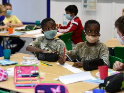 Pupils, wearing face masks, learn with their teacher during a summer project at the primary school 'Sonnenschule' in Beckum, western Germany, on July 6, 2021. - North-Rhine Westphalia's Minister of Education and Schools visits projects that have received funding from the state programme "Extra Time for Learning" during the summer. …