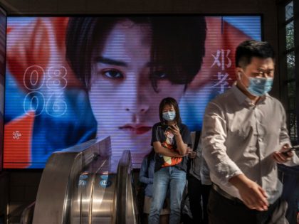 BEIJING, CHINA - AUGUST 06: Commuters wear protective masks to prevent COVID-19 as they come off an escalator at a metro station on August 6, 2021 in Beijing, China. While cases still remain relatively low compared to many countries, China is battling its worst COVID-19 outbreak in months after workers …