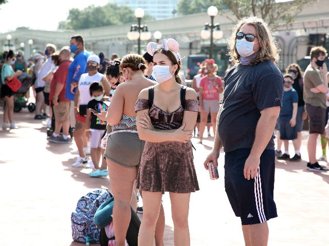 Guests wearing protective masks wait outside the Magic Kingdom theme park at Walt Disney World on the first day of reopening, in Orlando, Florida, on July 11, 2020. - Disney's flagship theme park reopened its doors to the general public on Saturday, along with Animal Kingdom, as part of their …
